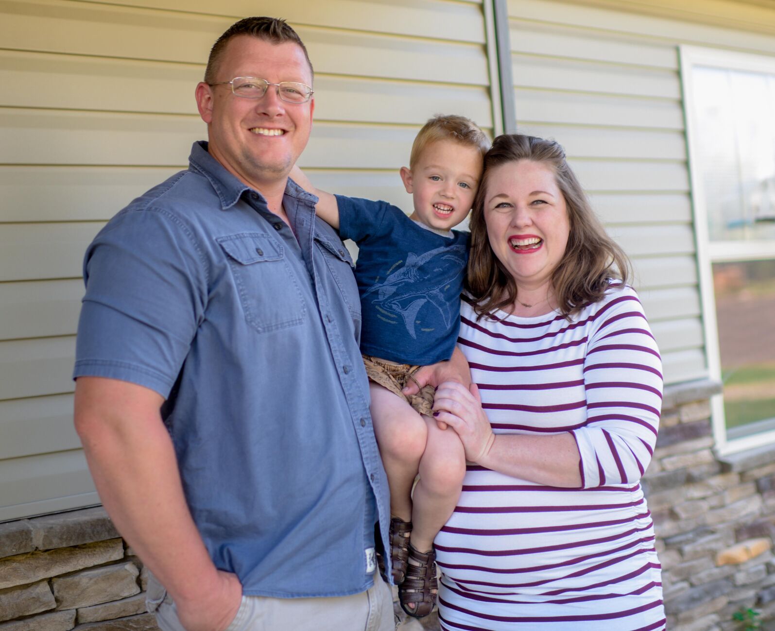 The Anderson family stands on their porch for a portrait